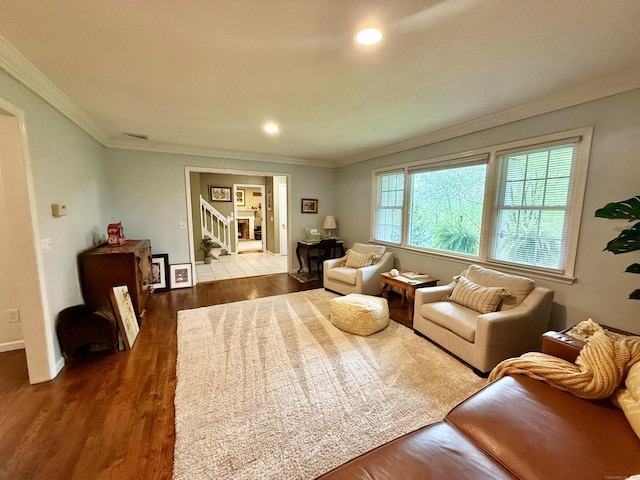 living room with crown molding, recessed lighting, baseboards, and wood finished floors