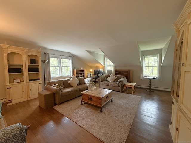 living room with a baseboard heating unit, a wealth of natural light, and dark wood-style floors