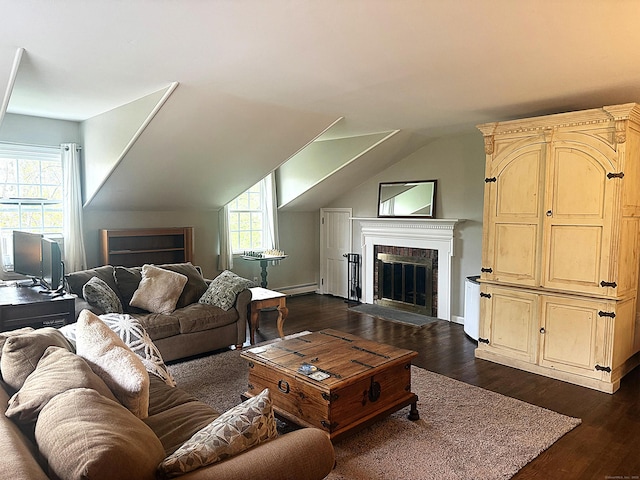 living room featuring vaulted ceiling, a fireplace, a baseboard heating unit, and dark wood-style floors