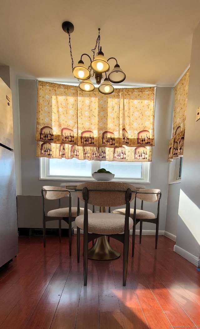 dining space featuring an inviting chandelier, baseboards, and hardwood / wood-style floors