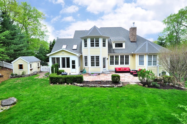 rear view of house featuring a patio, an outdoor hangout area, a sunroom, a chimney, and roof with shingles