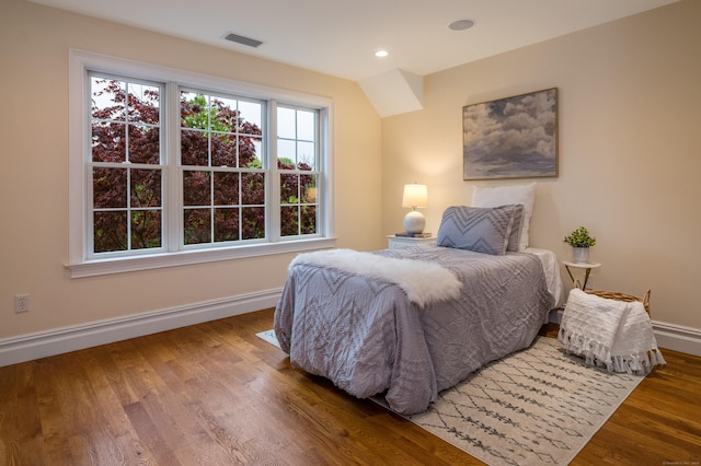 bedroom with baseboards, wood finished floors, and recessed lighting