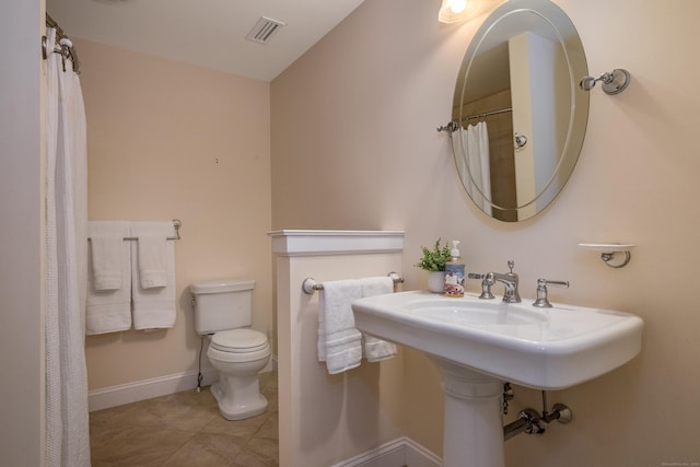 full bath featuring toilet, tile patterned floors, and baseboards