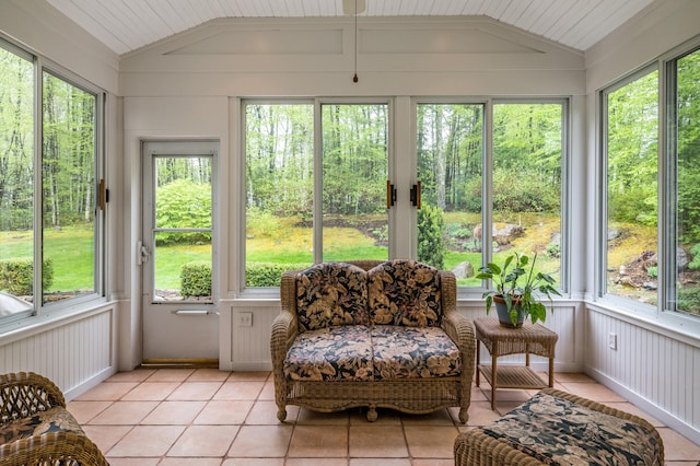 sunroom / solarium with vaulted ceiling, healthy amount of natural light, and tile patterned floors