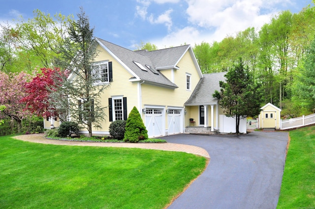 traditional-style house featuring a shingled roof and driveway