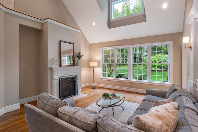 living area featuring baseboards, a fireplace, wood finished floors, high vaulted ceiling, and recessed lighting