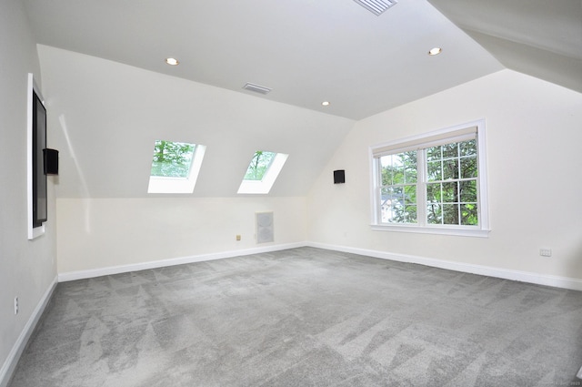 additional living space featuring a skylight, lofted ceiling, carpet floors, baseboards, and recessed lighting