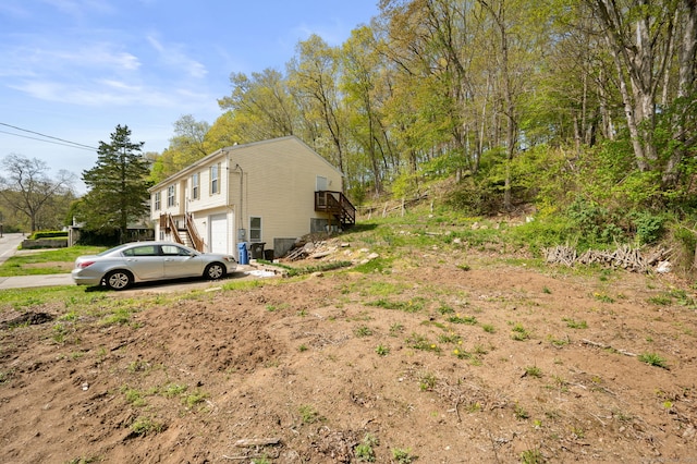 24 Fort Shantok Rd, Montville, CT 06382 - view of yard with stairs, an attached garage, and driveway