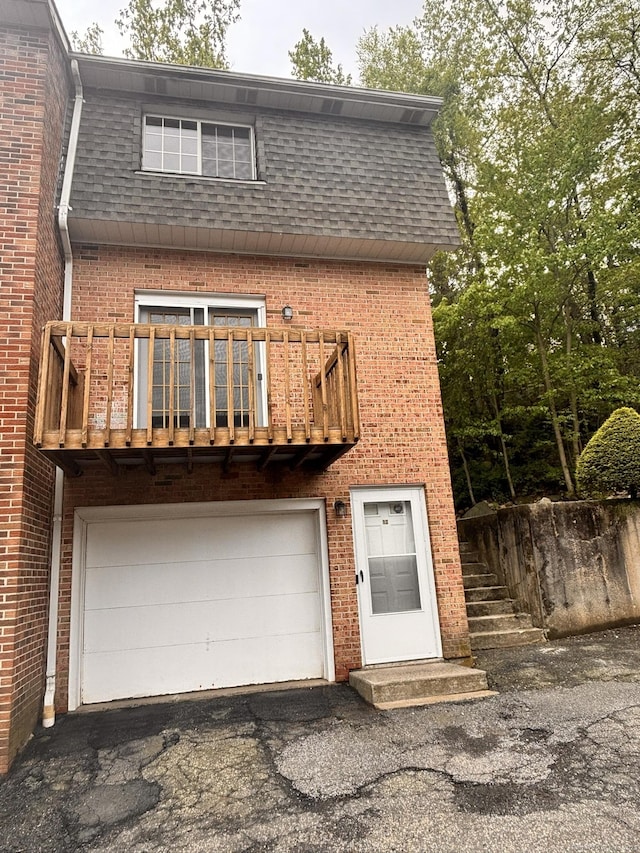 109 Bucks Hill Rd Unit 12, Waterbury, CT 06704 - view of front of property featuring brick siding, a garage, mansard roof, roof with shingles, and asphalt driveway