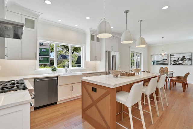 137 Millard St, Fairfield, CT 06824 - kitchen featuring stainless steel appliances, recessed lighting, a center island, light wood finished floors, and light stone counters