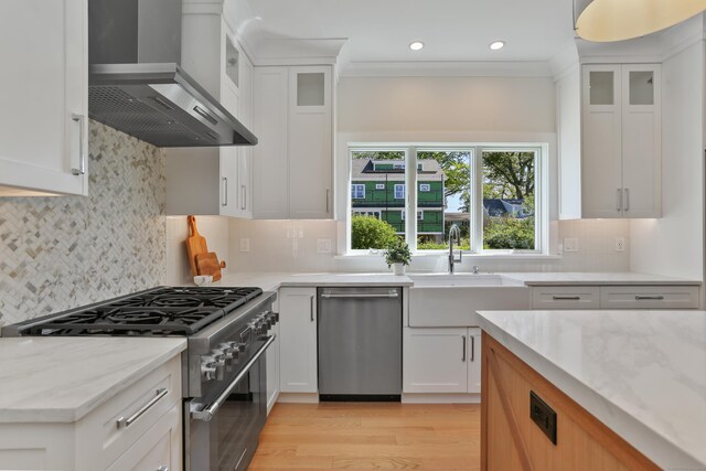 137 Millard St, Fairfield, CT 06824 - kitchen with wall chimney range hood, appliances with stainless steel finishes, light stone countertops, white cabinets, and recessed lighting