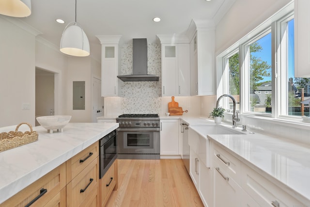 137 Millard St, Fairfield, CT 06824 - kitchen with wall chimney range hood, appliances with stainless steel finishes, electric panel, light wood finished floors, and ornamental molding