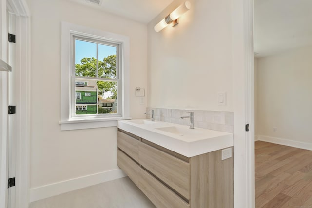 137 Millard St, Fairfield, CT 06824 - bathroom featuring double vanity, decorative backsplash, and wood finished floors