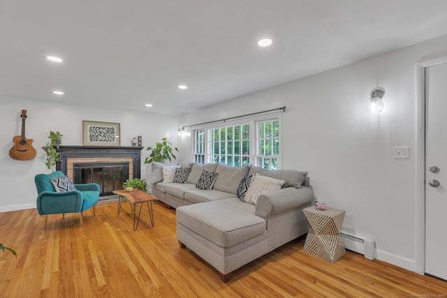 living room with recessed lighting, baseboards, a baseboard radiator, and light wood finished floors