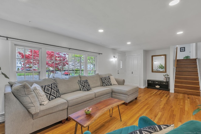 living room featuring recessed lighting, baseboards, light wood finished floors, and stairs