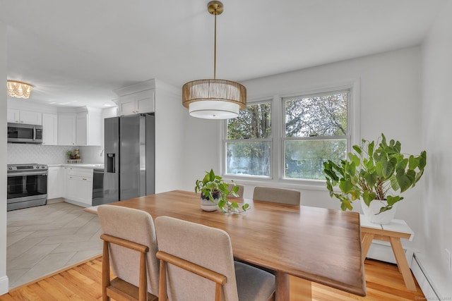 dining space featuring light wood-style flooring and baseboard heating