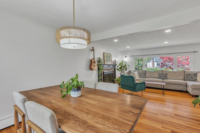 dining space featuring a baseboard heating unit, recessed lighting, and wood finished floors