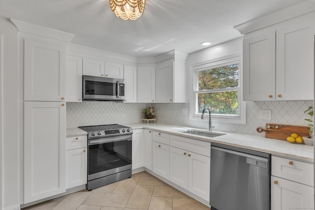 kitchen featuring a sink, white cabinetry, light tile patterned floors, and stainless steel appliances