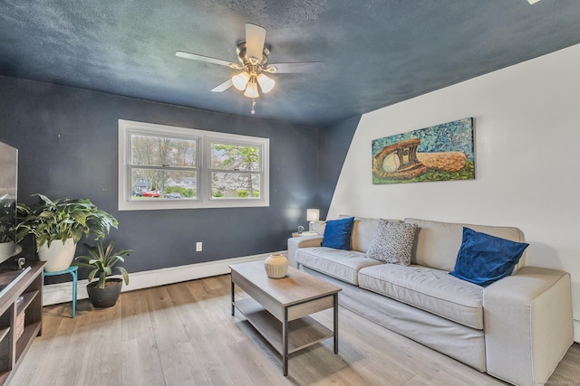 living area featuring baseboards, ceiling fan, and wood finished floors
