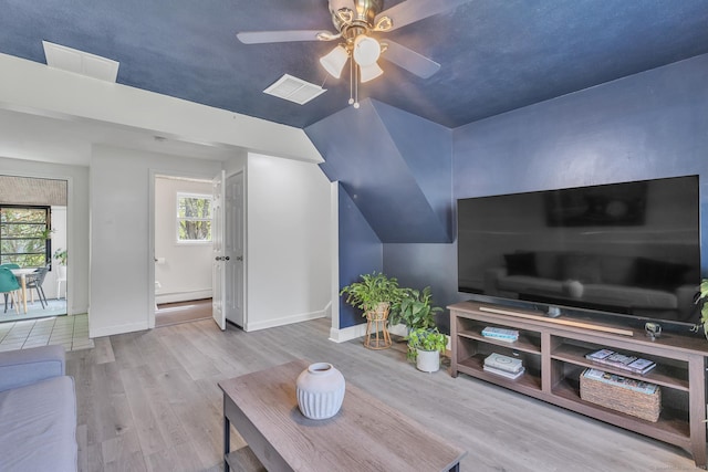 living area with a ceiling fan, visible vents, and wood finished floors