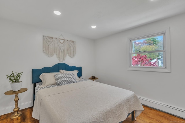 bedroom with recessed lighting, baseboards, baseboard heating, and wood finished floors