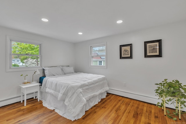bedroom featuring baseboard heating, recessed lighting, and light wood-style flooring
