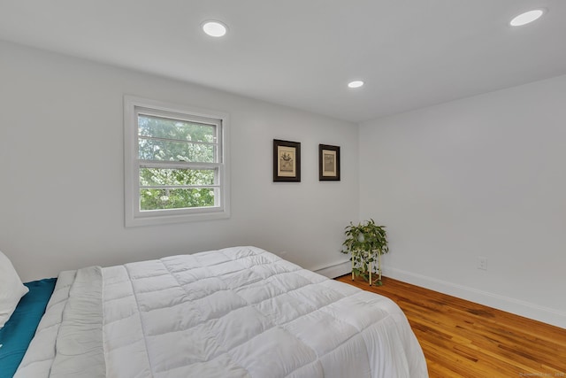bedroom featuring baseboards, recessed lighting, and wood finished floors