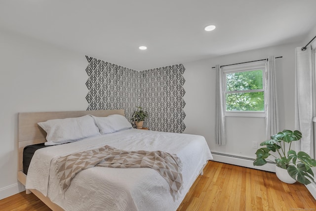 bedroom with baseboard heating, recessed lighting, and wood finished floors