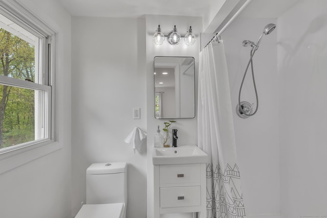 full bath with vanity, curtained shower, a wealth of natural light, and toilet