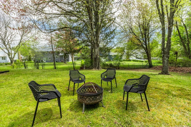 view of yard with fence and a fire pit