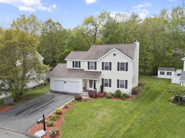 9 Baldwin Dr, Farmington, CT 06032 - colonial-style house featuring a chimney, driveway, a front lawn, roof with shingles, and an outdoor structure