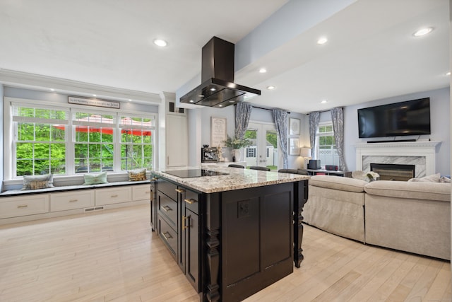 9 Baldwin Dr, Farmington, CT 06032 - kitchen with island range hood, black electric stovetop, light wood-style flooring, light stone countertops, and recessed lighting
