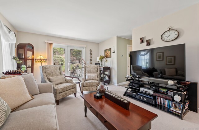 carpeted living area featuring baseboards