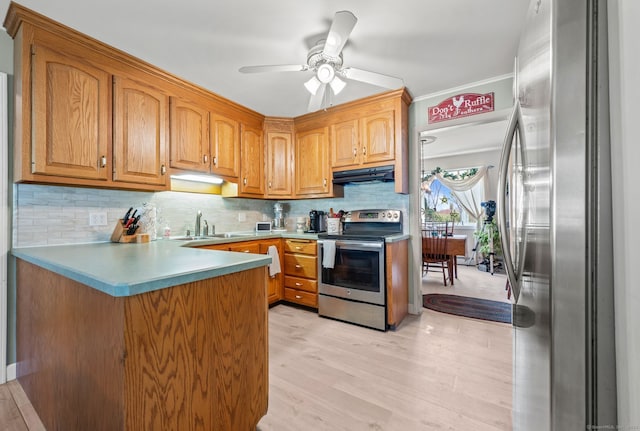 kitchen with appliances with stainless steel finishes, under cabinet range hood, a peninsula, a ceiling fan, and backsplash