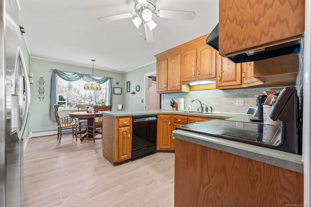 kitchen featuring black dishwasher, a sink, a peninsula, crown molding, and stainless steel fridge