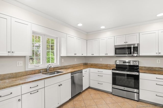 kitchen featuring a sink, stainless steel appliances, crown molding, white cabinetry, and light tile patterned flooring