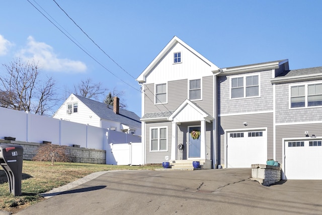 74 Sterling St, Fairfield, CT 06825 - view of front of home with board and batten siding, fence, a garage, and driveway