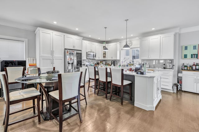 74 Sterling St, Fairfield, CT 06825 - kitchen with white cabinets, appliances with stainless steel finishes, decorative backsplash, and ornamental molding