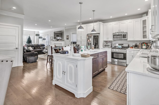 74 Sterling St, Fairfield, CT 06825 - kitchen with crown molding, white cabinetry, stainless steel appliances, and open floor plan