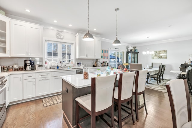 74 Sterling St, Fairfield, CT 06825 - kitchen with backsplash, a breakfast bar, and light wood-type flooring