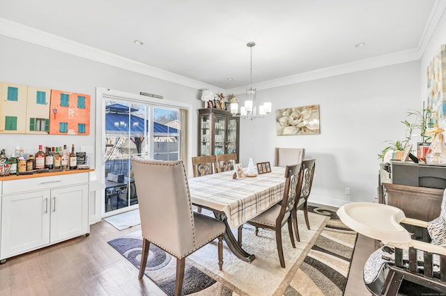 74 Sterling St, Fairfield, CT 06825 - dining space featuring an inviting chandelier, light wood-type flooring, a bar, and ornamental molding