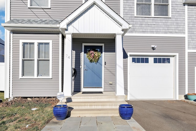 74 Sterling St, Fairfield, CT 06825 - doorway to property with an attached garage and board and batten siding