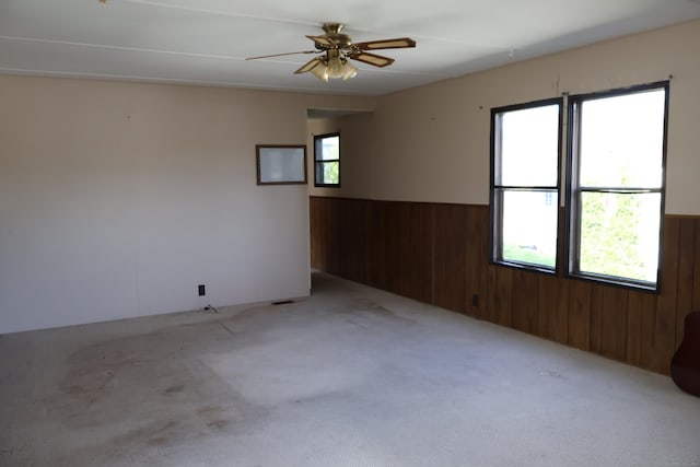 325 Kelly Rd Unit Vt44, Vernon, CT 06066 - carpeted empty room featuring wooden walls, a wainscoted wall, and a ceiling fan