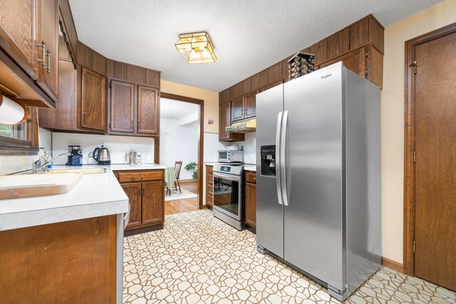 214 Candlewyck Dr, Newington, CT 06111 - kitchen featuring a sink, under cabinet range hood, light countertops, baseboards, and appliances with stainless steel finishes