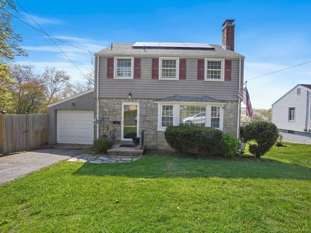 134 Painter Ave, West Haven, CT 06516 - view of front of house with a front lawn, fence, stone siding, concrete driveway, and solar panels