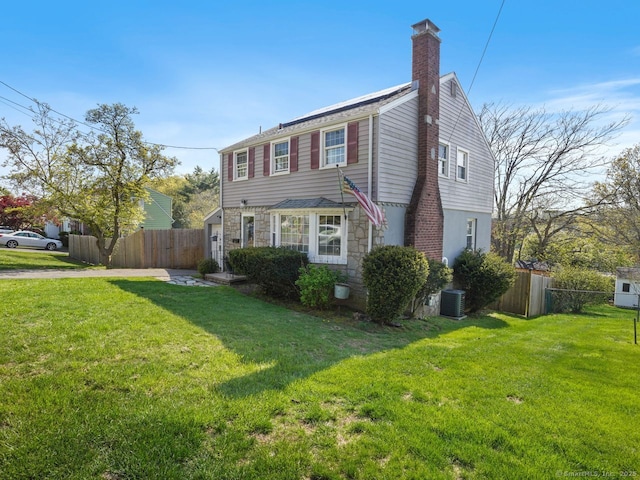 134 Painter Ave, West Haven, CT 06516 - view of front of house with fence, a chimney, a front lawn, and stone siding
