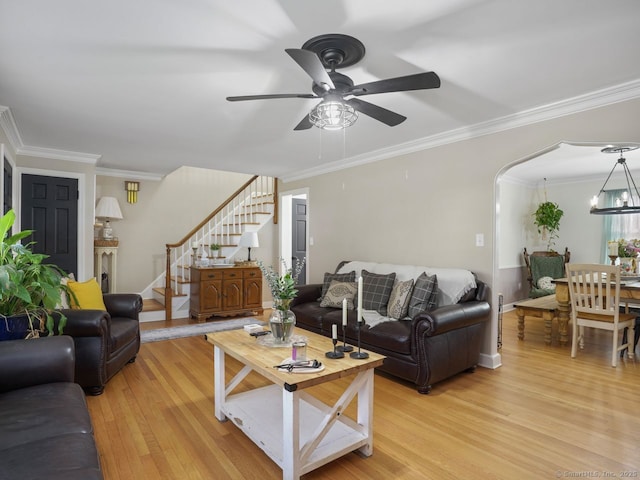 134 Painter Ave, West Haven, CT 06516 - living area featuring crown molding, arched walkways, light wood-style flooring, ceiling fan with notable chandelier, and stairs
