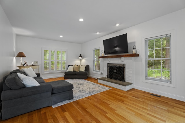 202 Horse Hill Rd, Westbrook, CT 06498 - living room with healthy amount of natural light, a brick fireplace, wood finished floors, recessed lighting, and baseboards