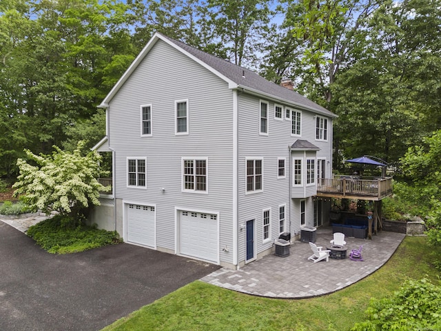 202 Horse Hill Rd, Westbrook, CT 06498 - rear view of house featuring a chimney, driveway, an attached garage, a patio area, and a wooden deck