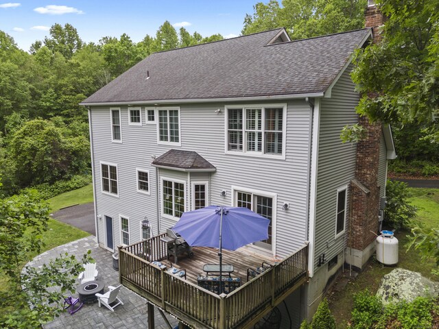 202 Horse Hill Rd, Westbrook, CT 06498 - back of property featuring a chimney, a deck, a shingled roof, an outdoor fire pit, and a patio